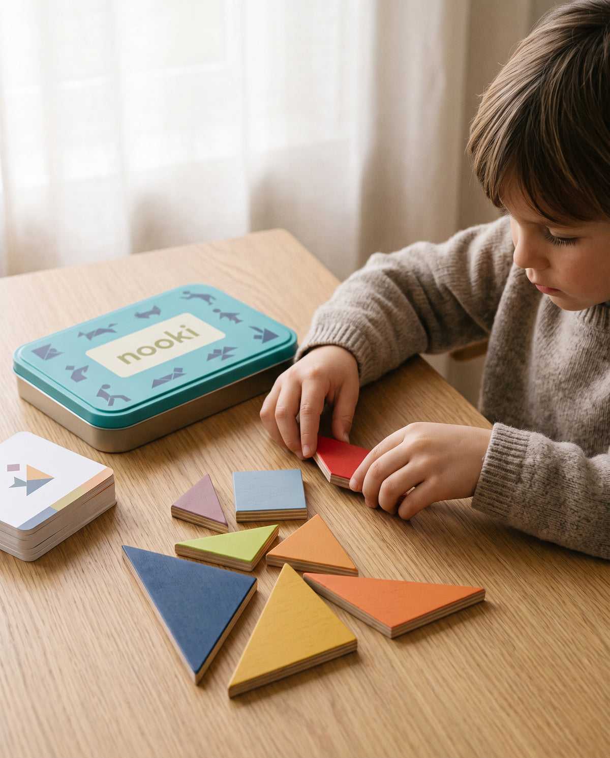 Niño de seis años concentrado colocando una pieza del tangram Enigma sobre la mesa