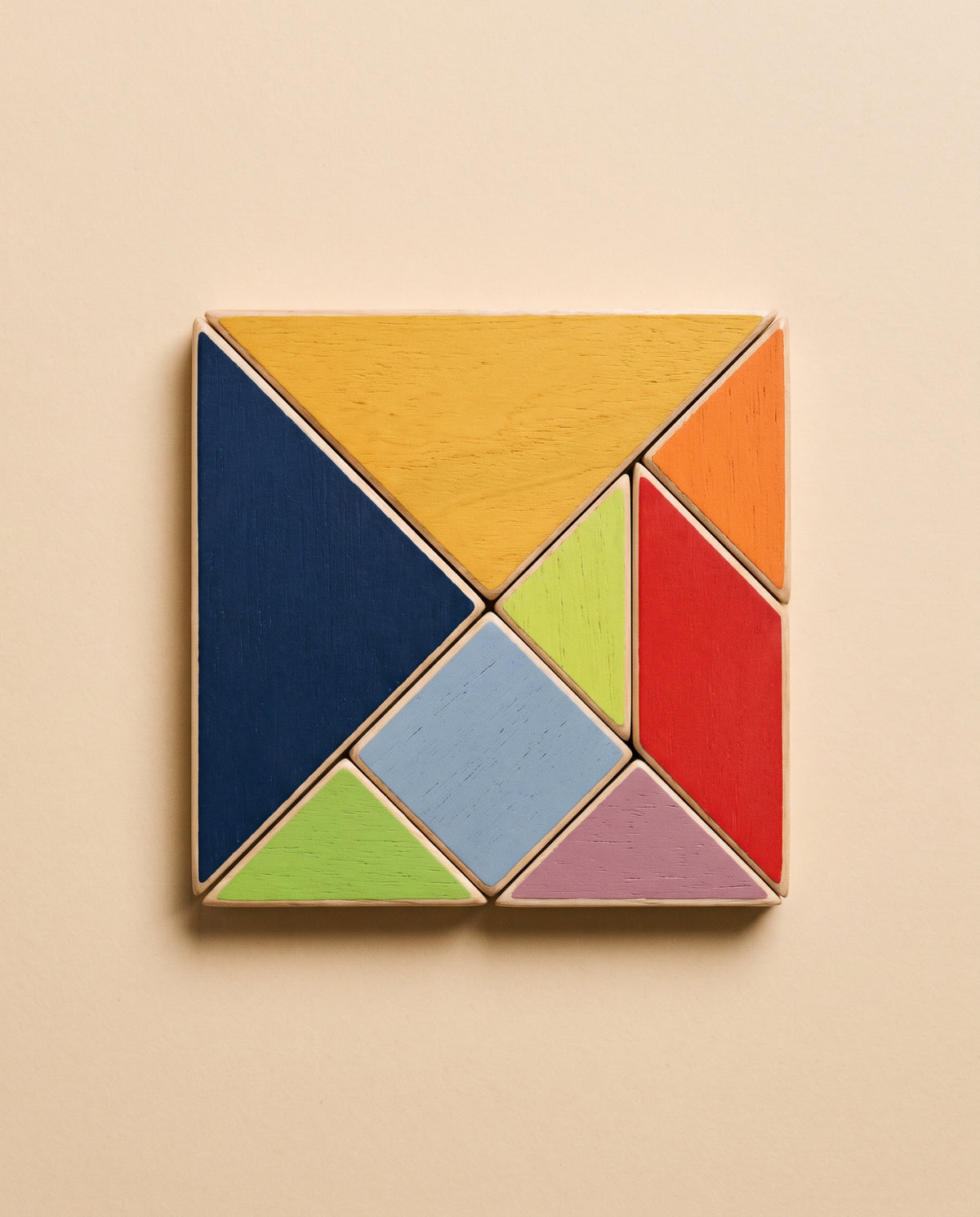 Las siete piezas de madera de Enigma montadas formando el cuadrado clásico del tangram, vistas desde arriba