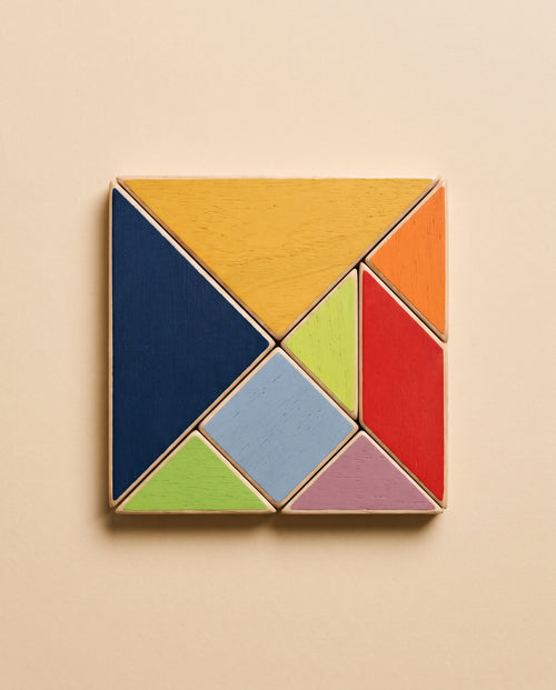 Las siete piezas de madera de Enigma montadas formando el cuadrado clásico del tangram, vistas desde arriba